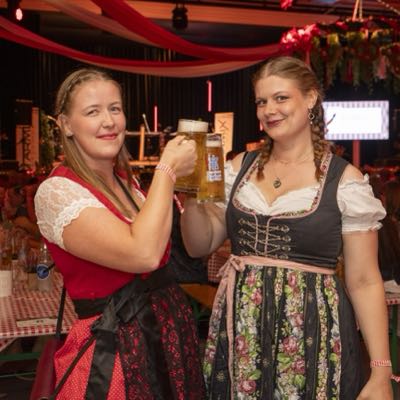 Zwei Besucherinnen im Dirndl stossen mit der Mass an